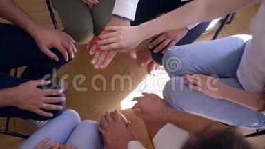 <strong>团队精神</strong>，年轻人在集体疗法中做一叠手，上下移动